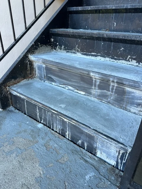 Close view of replacement steel stair tread pans with visible weld seams along their edges
