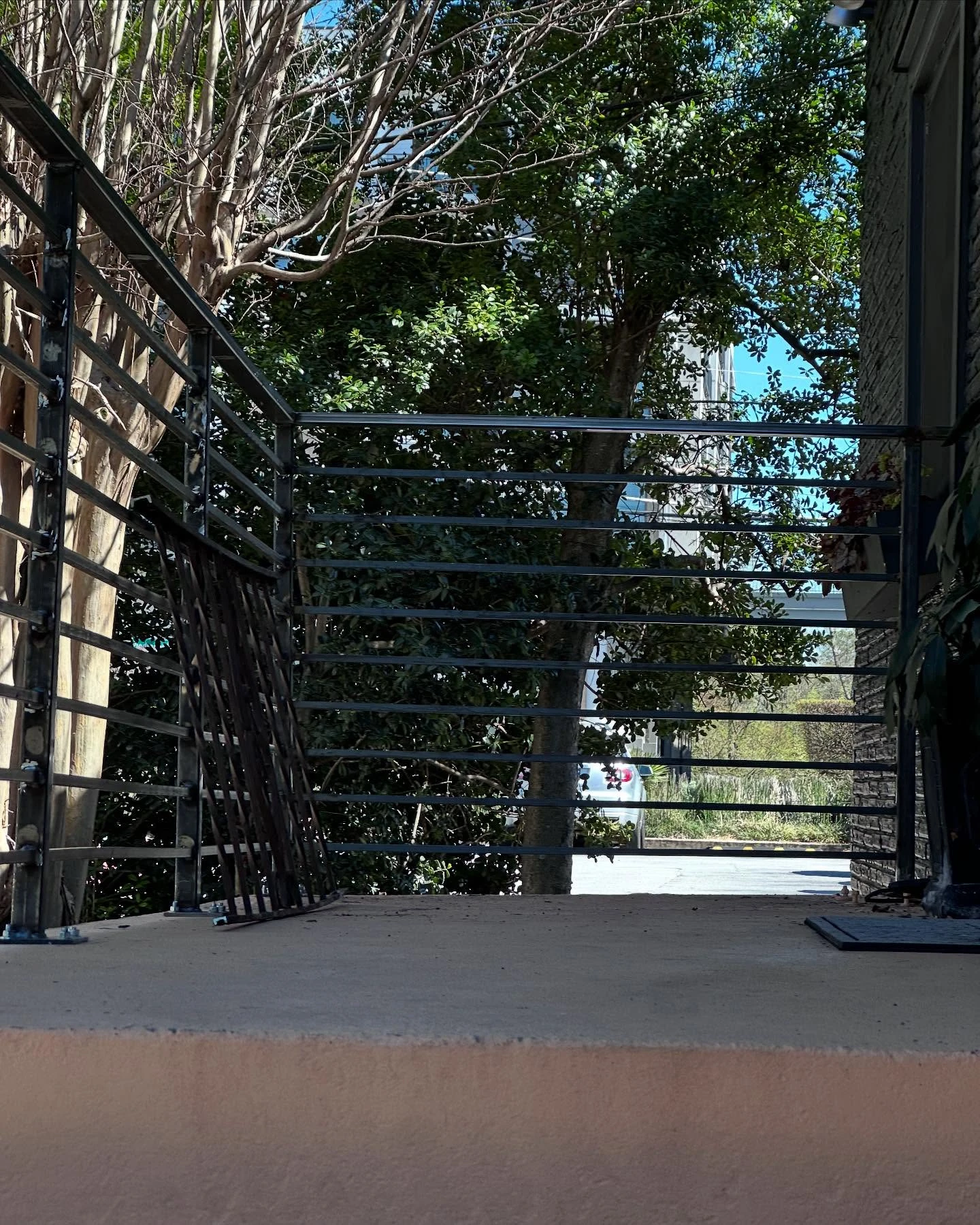 Close view of the new horizontal bar steel railing running along the upper walkway